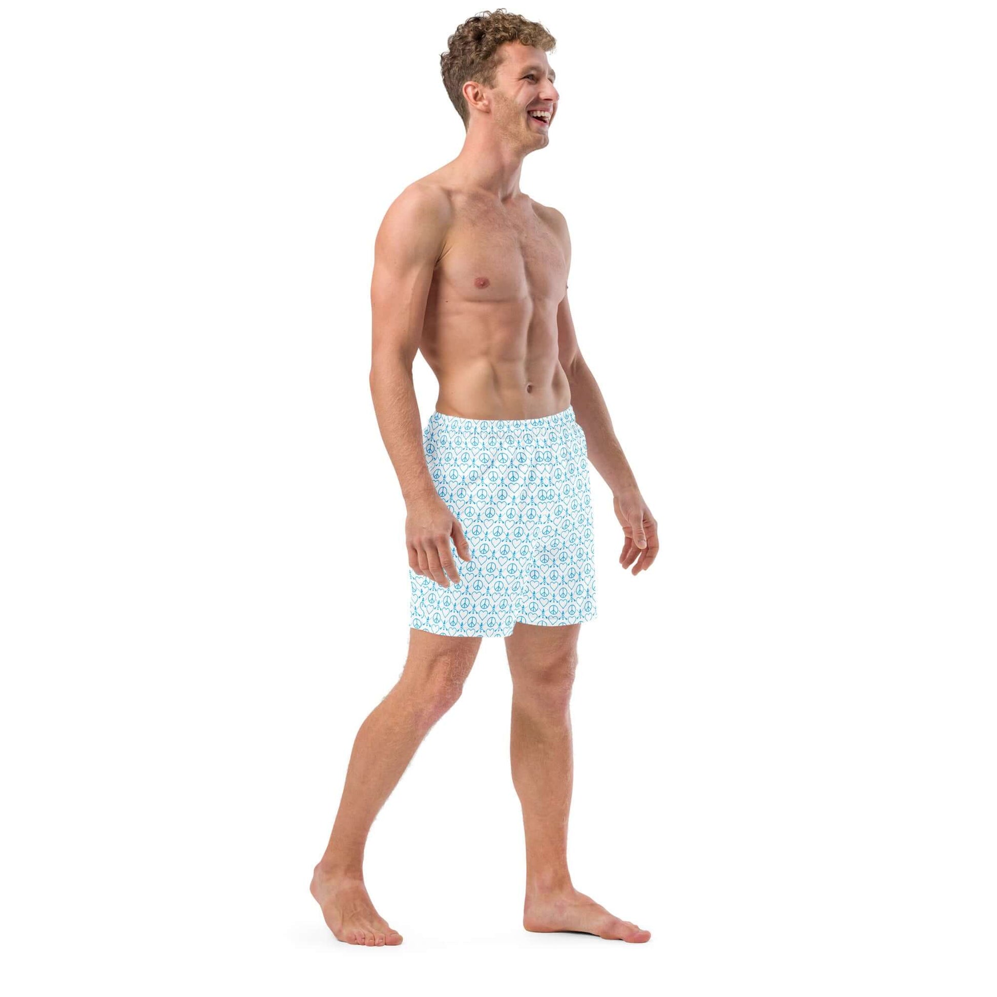 Man wearing Recycled Peace Love Paddleboard Swim Trunks, smiling and walking, perfect for summer fun.
