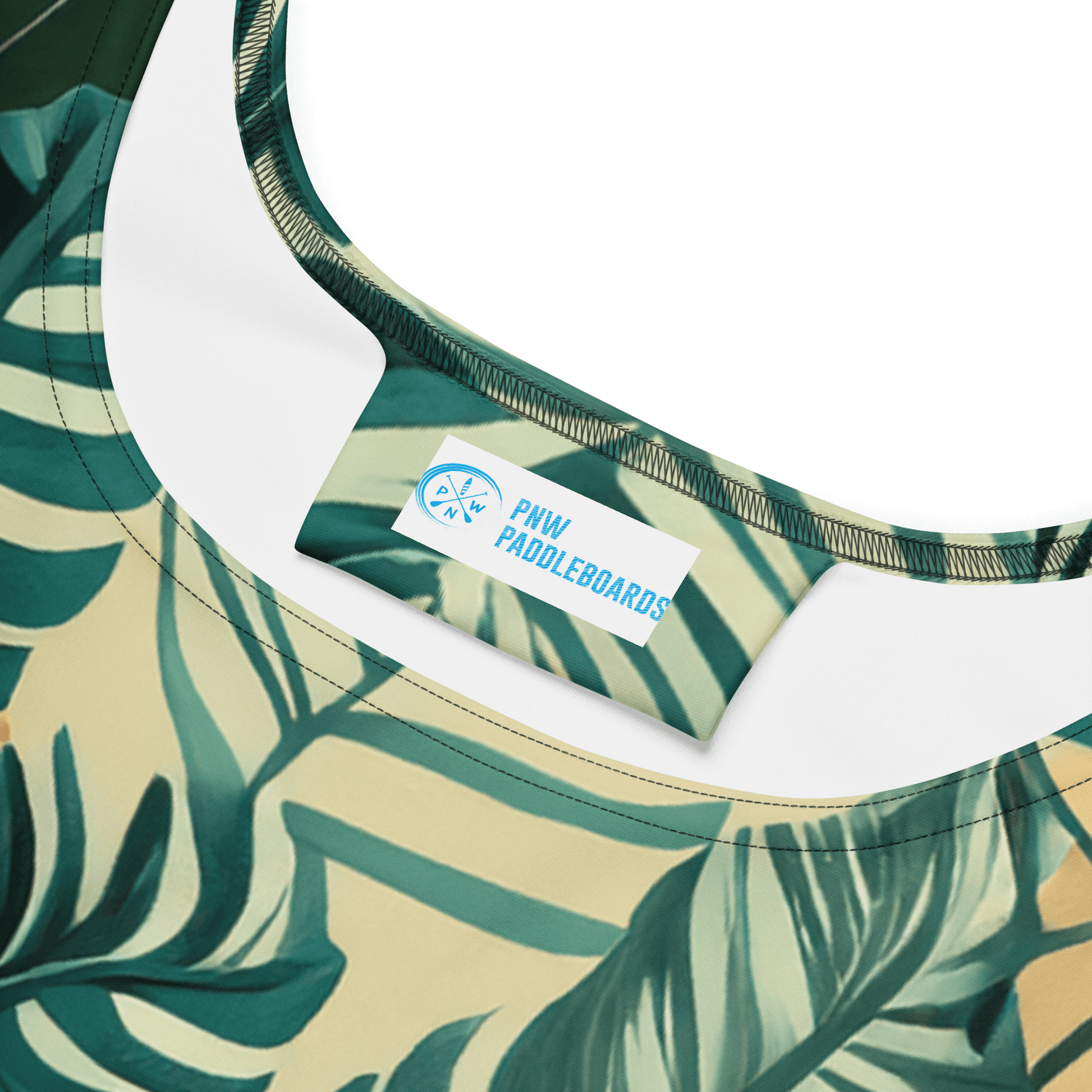 Close-up of PNW Tropical Camo Skater Dress neckline with tropical leaf design and PNW Paddleboards tag.